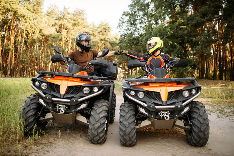 Two atv riders hits fists for good luck, back view